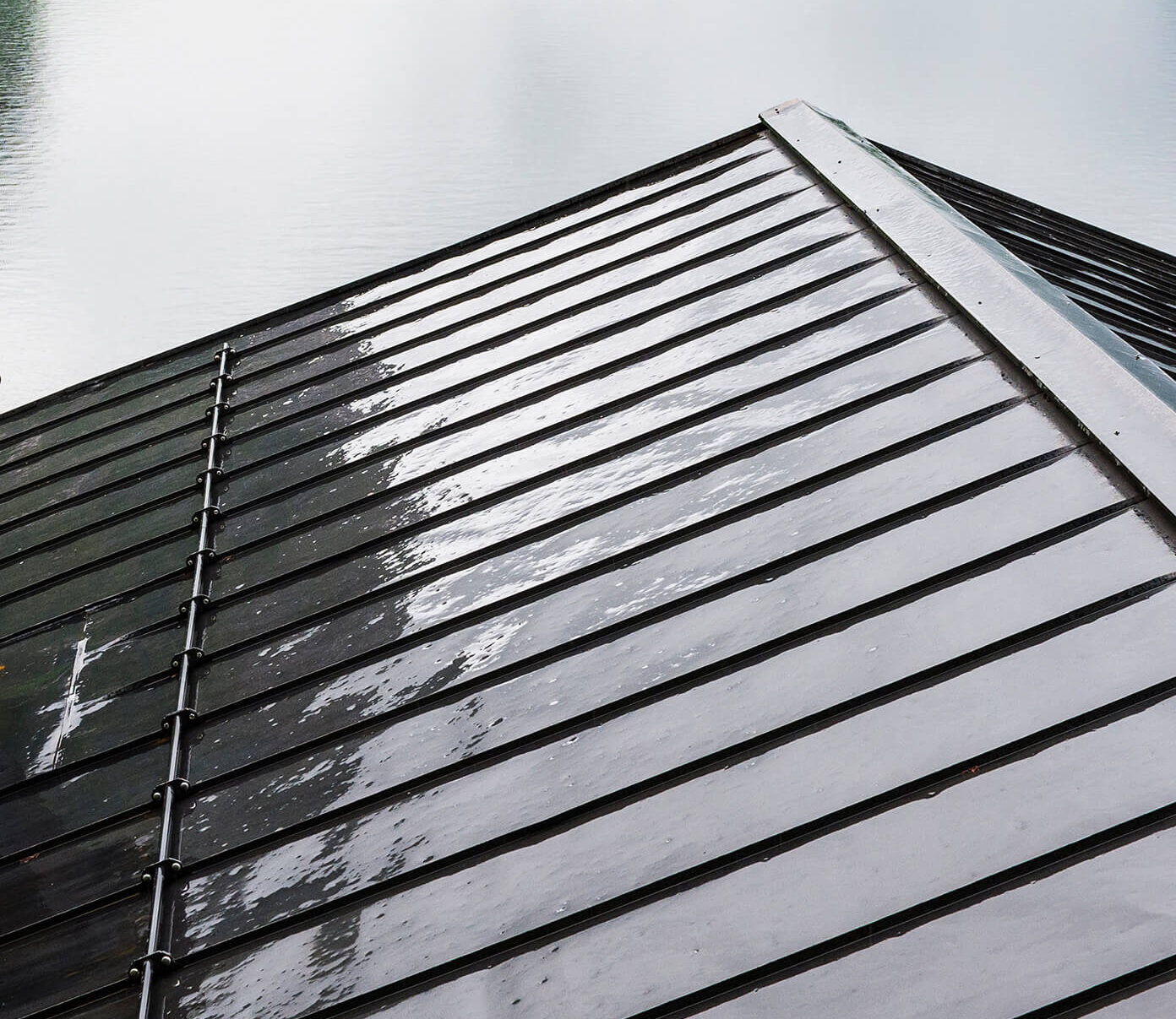 Close-up of a dark standing seam metal roof with snow guards installed on a home in Conneaut Lake, PA.