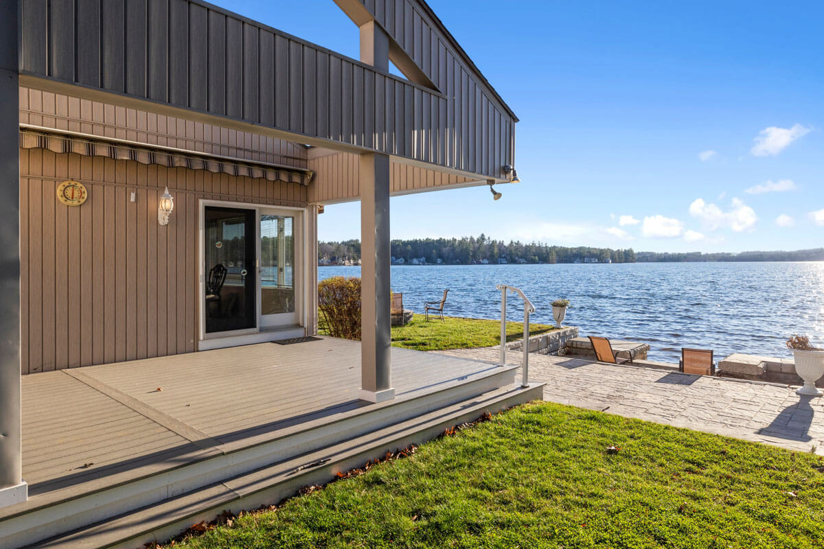 akefront home with light vertical siding and a patio deck directly overlooking Chautauqua Lake in Mayville and Chautauqua, NY.