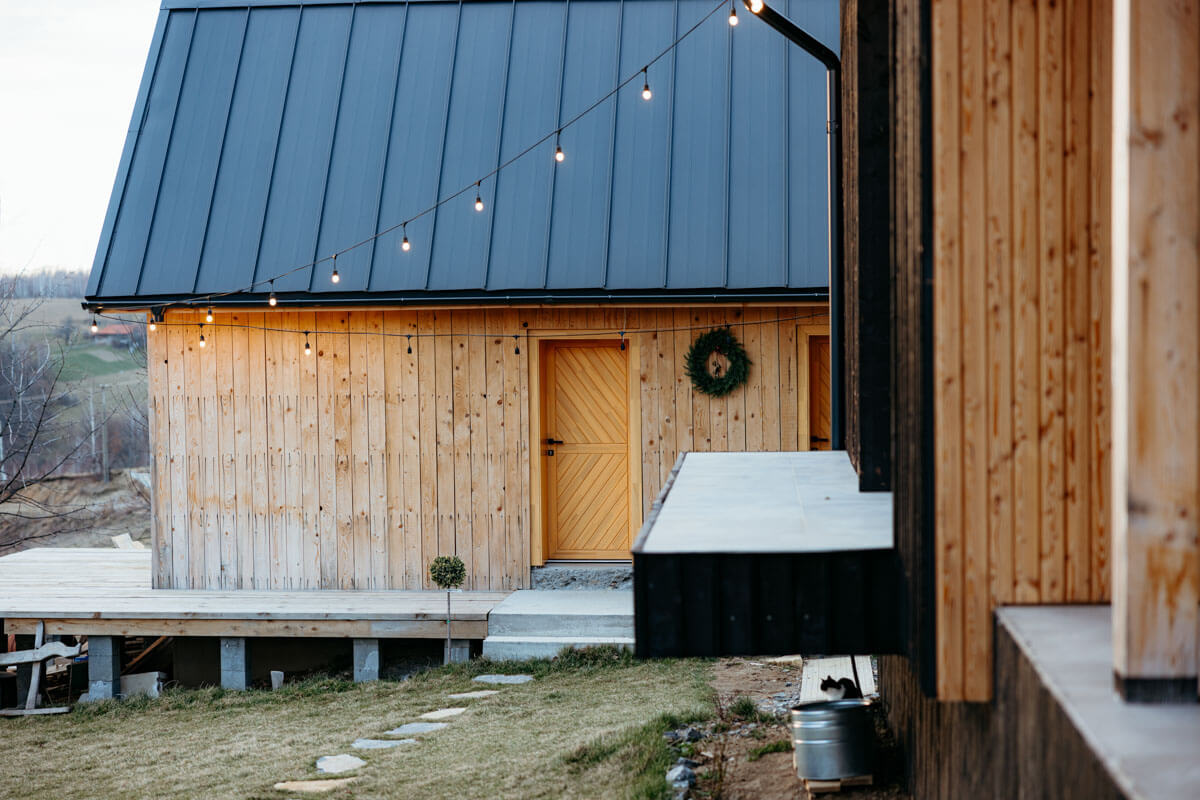 Modern light wood cabin with a black standing seam metal roof installed in Meadville, PA.